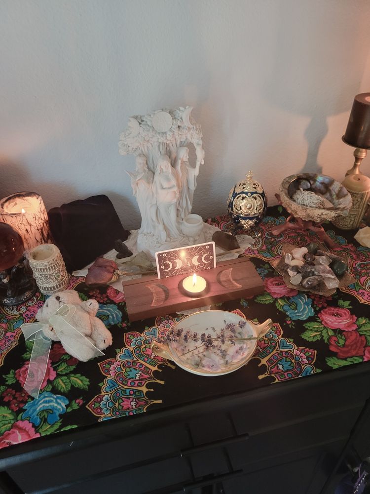 My altar with the triple goddess statue and candles burning
