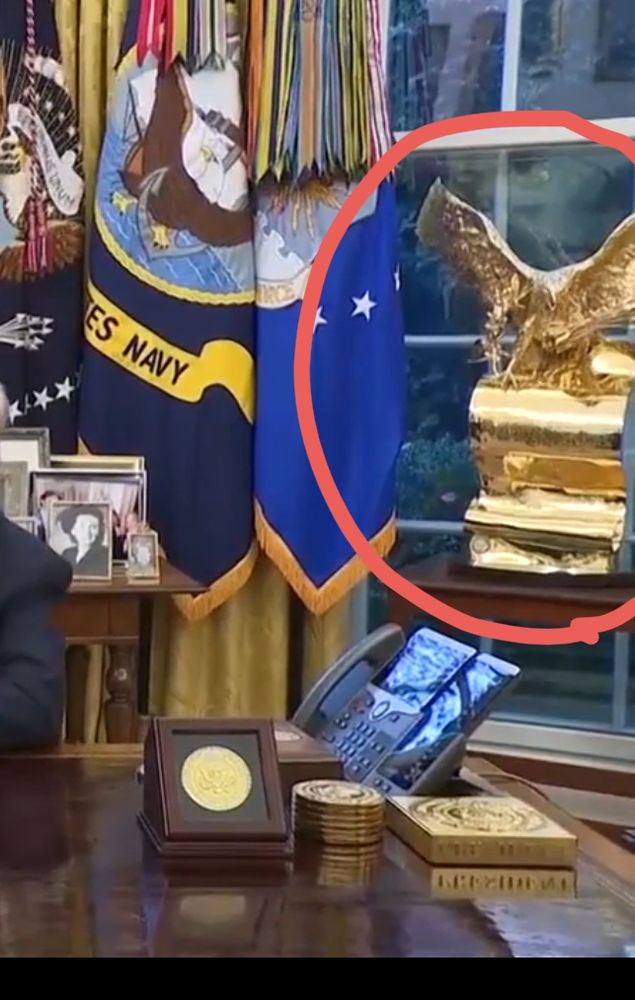 Cropped detail of the oval office with a giant gold eagle statue circled in red
