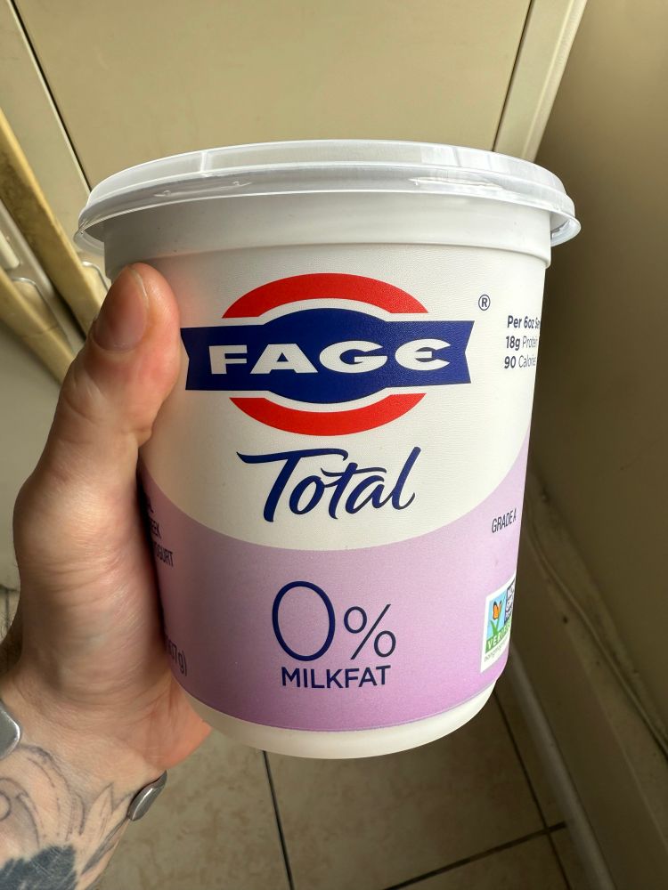 Shot of a hand holding a container of Fage yogurt 