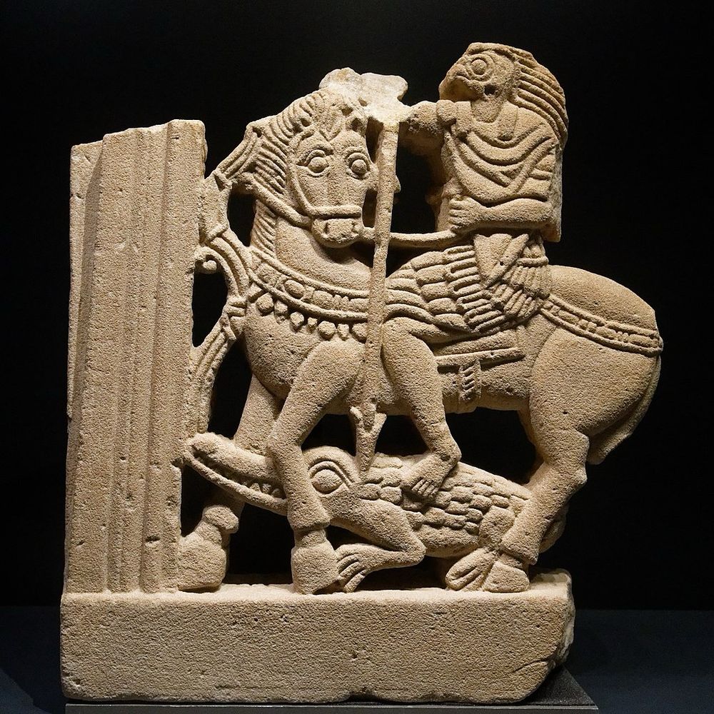 Stone carving (perhaps part of a window) showing a falcon-headed human riding on a horse. The figure drives a spear into a crocodile positioned beneath the horse’s feet. It has been suggested that the horseman represents Horus, the Egyptian god of kingship and the sky, and that the crocodile might be his rival the chaotic god Seth. The object is provenanced to the Nubian site of Faras and dates to the 4th Century CE.