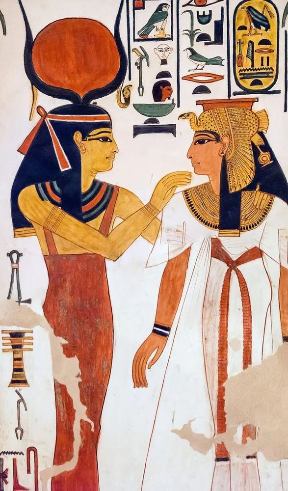Image of the goddess Hathor with Queen Nefertari in Nefertari’s tomb (19th Dynasty). Hathor heard a red dress and her head is crowned by two cow horns with a red sun disk between them.