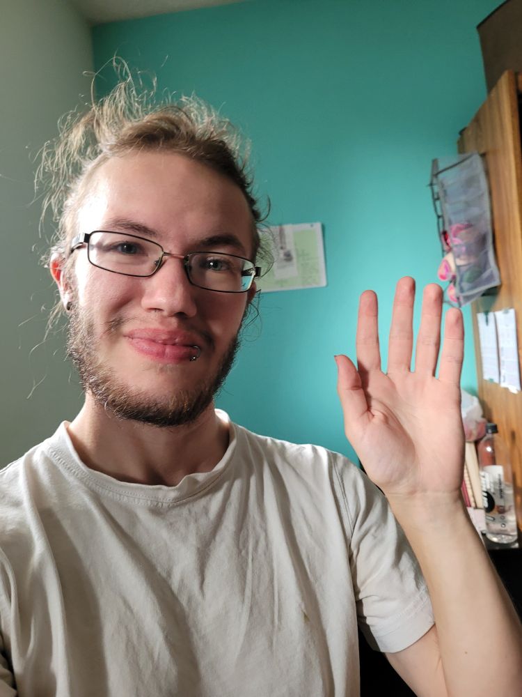 I'm waving at the camera and smiling.