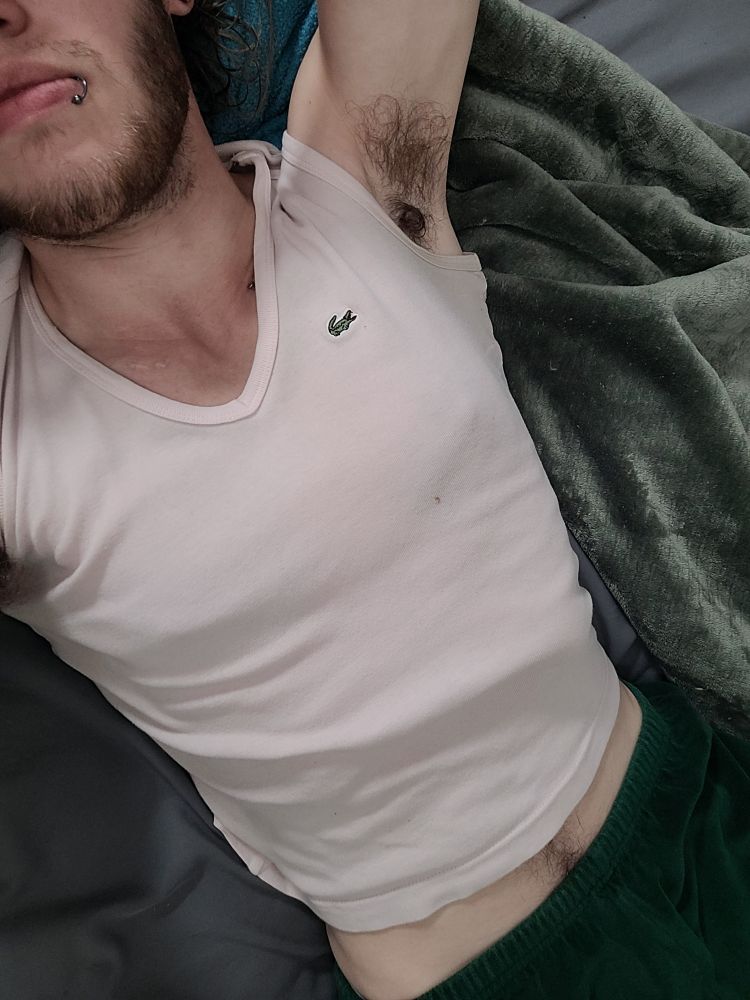 Laying in bed with an off-white pink tank top that's riding up my stomach, and dark green velvet pants