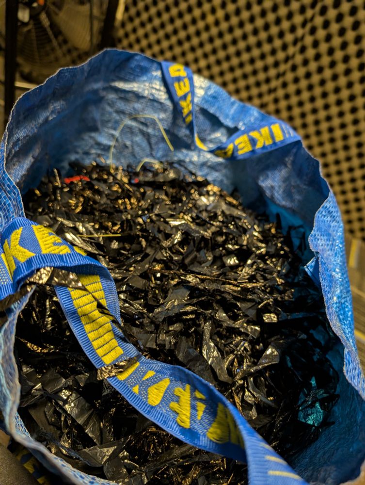 not real flowers, picture is of an IKEA bag full of black plastic ribbons used to mimic a rustling bundle of flowers