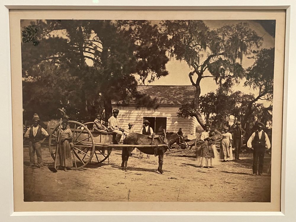 The photo, with folks spread around the image, and a horse cart in the center