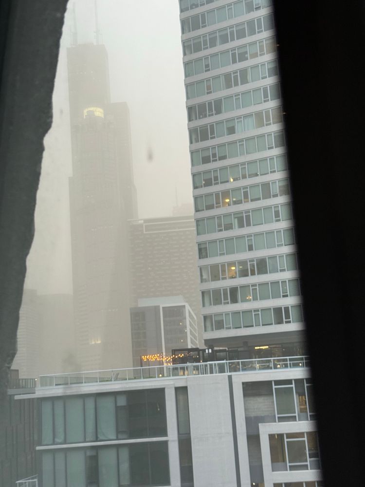 The Sears Tower and the supervillain lair-ass building in front of it obscured by dust. 