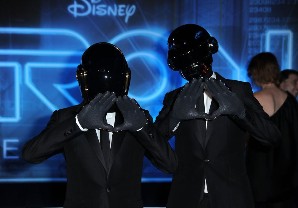 An image of Daft Punk at the premiere of the 2010 film "TRON: Legacy".

Both members are doing their iconic pyramid hand gesture while dressed in simple tuxedos.