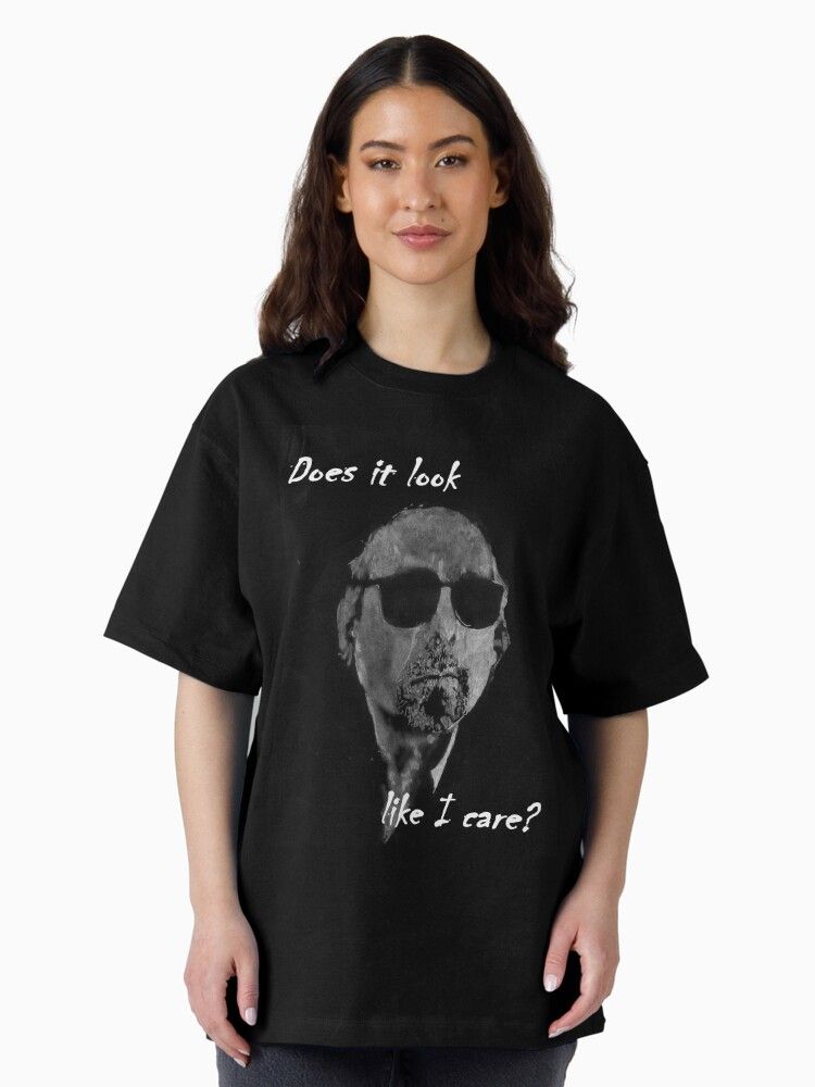 Woman wearing a black T-shirt with an image of a serious dog in sunglasses and text saying, “Does it look like I care?”, conveying humor.