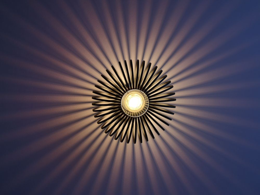 Eine Deckenlampe, die strahlenförmige Schatten wirft.
