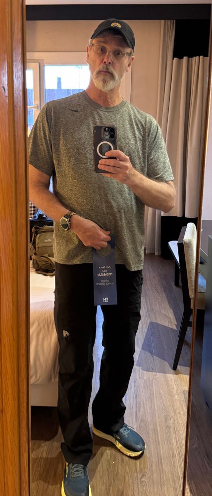 Old man holding a “no molestar” sign over his naughty bits.