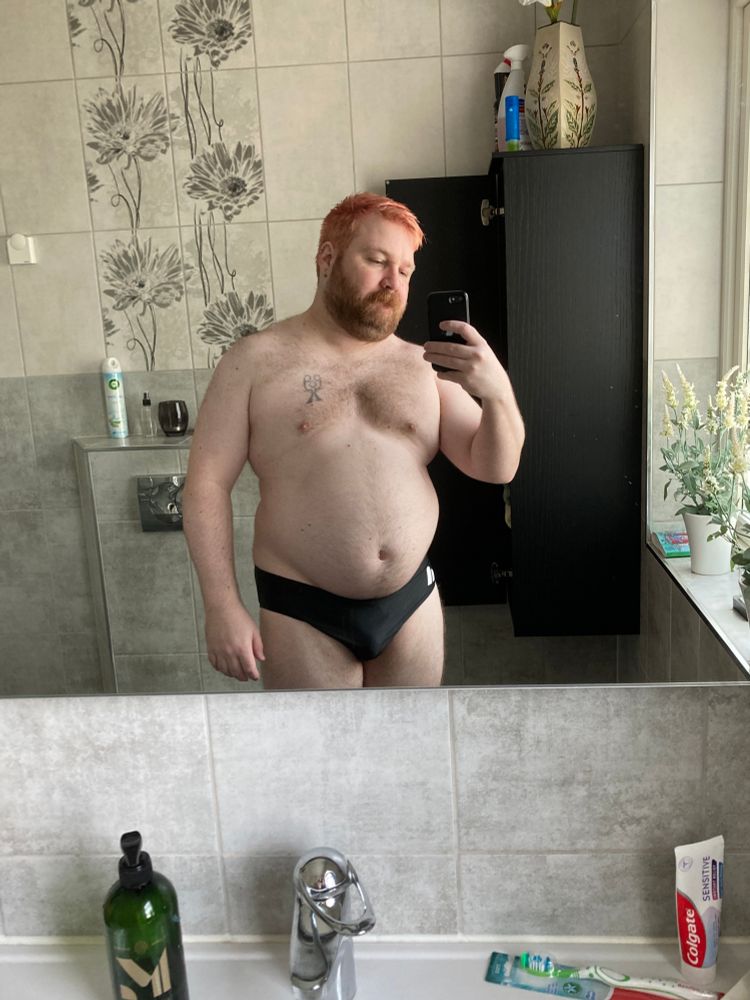 Me standing in front of mirror in a pair of speedos