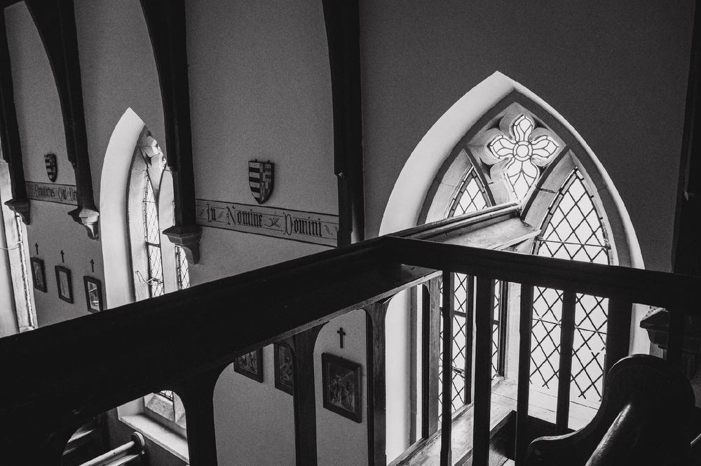 A black and white photograph of the interior of a chapel. It shows part of the balcony balustrade and the chapel below. 