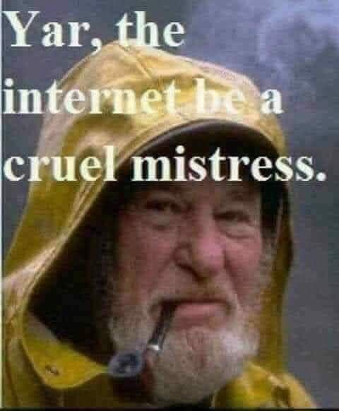 An old seaman smoking a pipe and saying, " Yar, the interet be a cruel mistress." he is wearing a yellow hoodie and has white beard