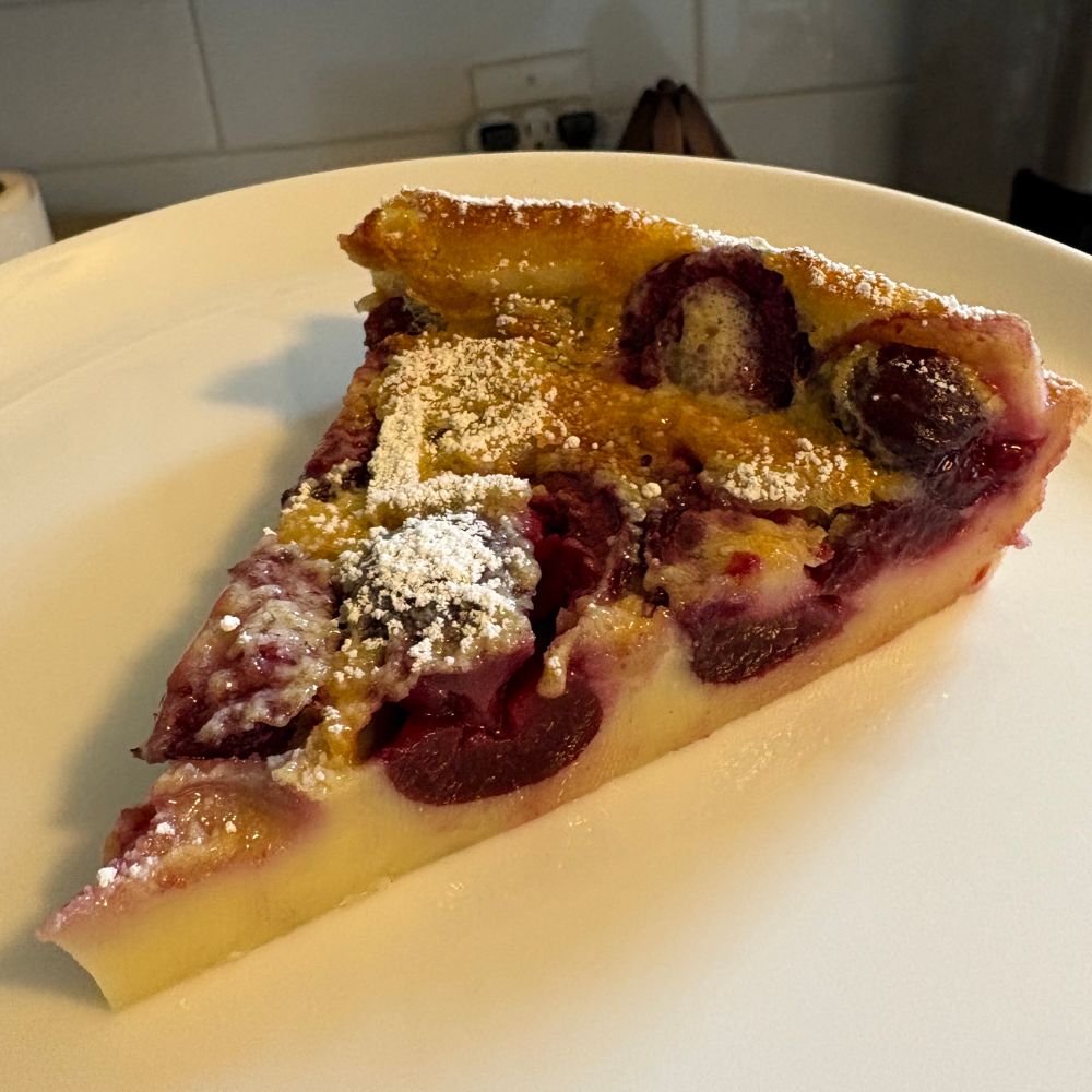 A slice of cherry clafoutis ready to eat.