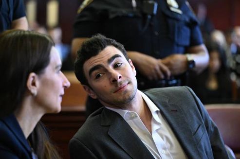 Luigi Mangione smiling at his attorney