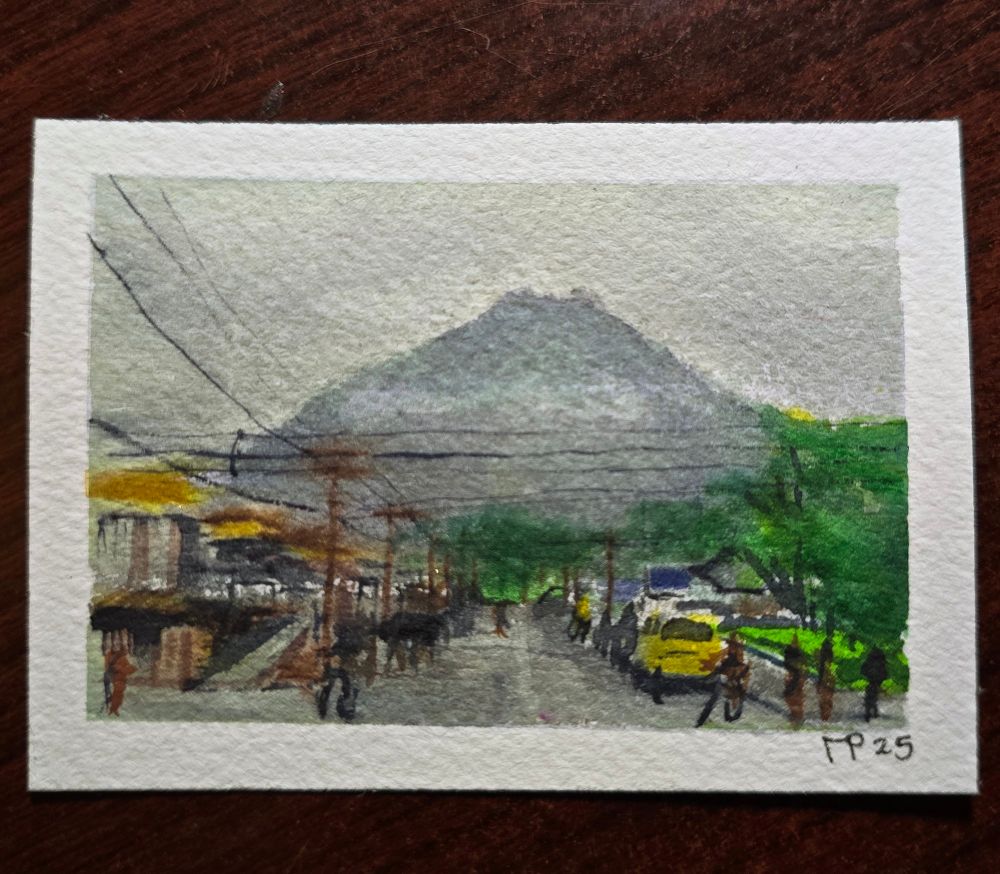 Art card sized watercolor painting of a large volcano rising in the hazy distance and looming over the bustling main Street of the town of La Fortuna, Costa Rica