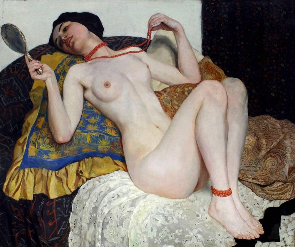 An oil painting of a reclining nude woman  clutching a necklace of coral as she gazes at herself through a compact mirror