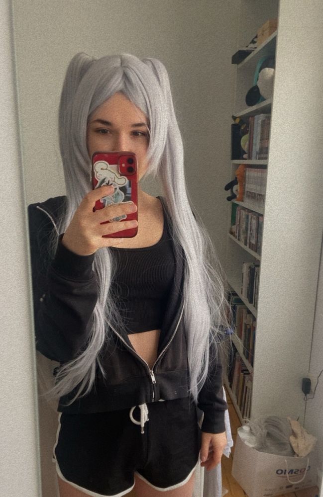 A girl with white hair and pigtail is making a selfie in a small and thight outfit