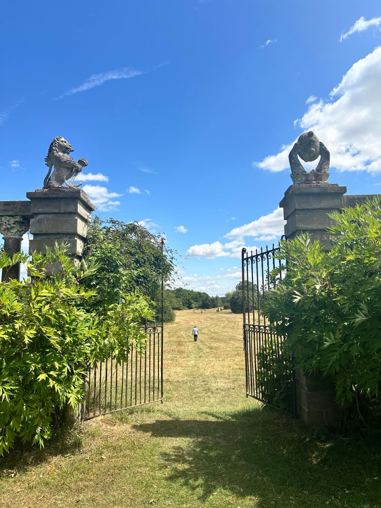 Grand gates leading to grassland.