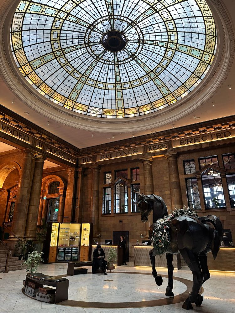 Interior of Victorian building. In the ceiling is a large glass dome. 