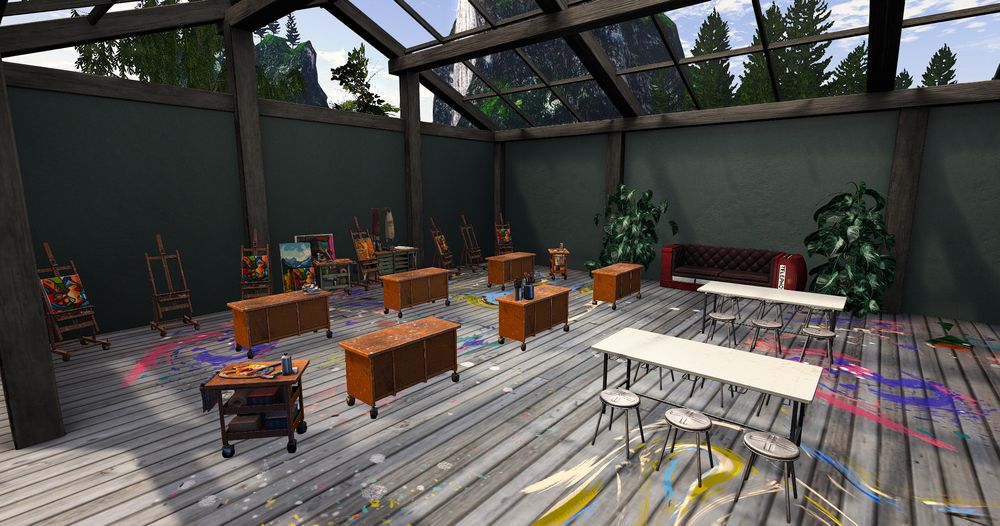 A secondlife screen shot of a building filled with art tables and easels, the floor is covered in paint platters 
