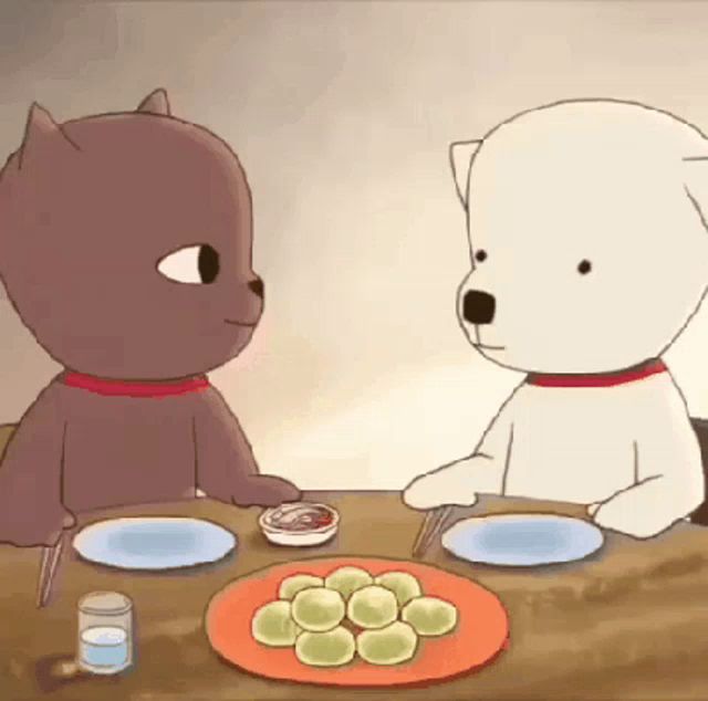 two teddy bears are sitting at a table with plates and a bowl of ketchup