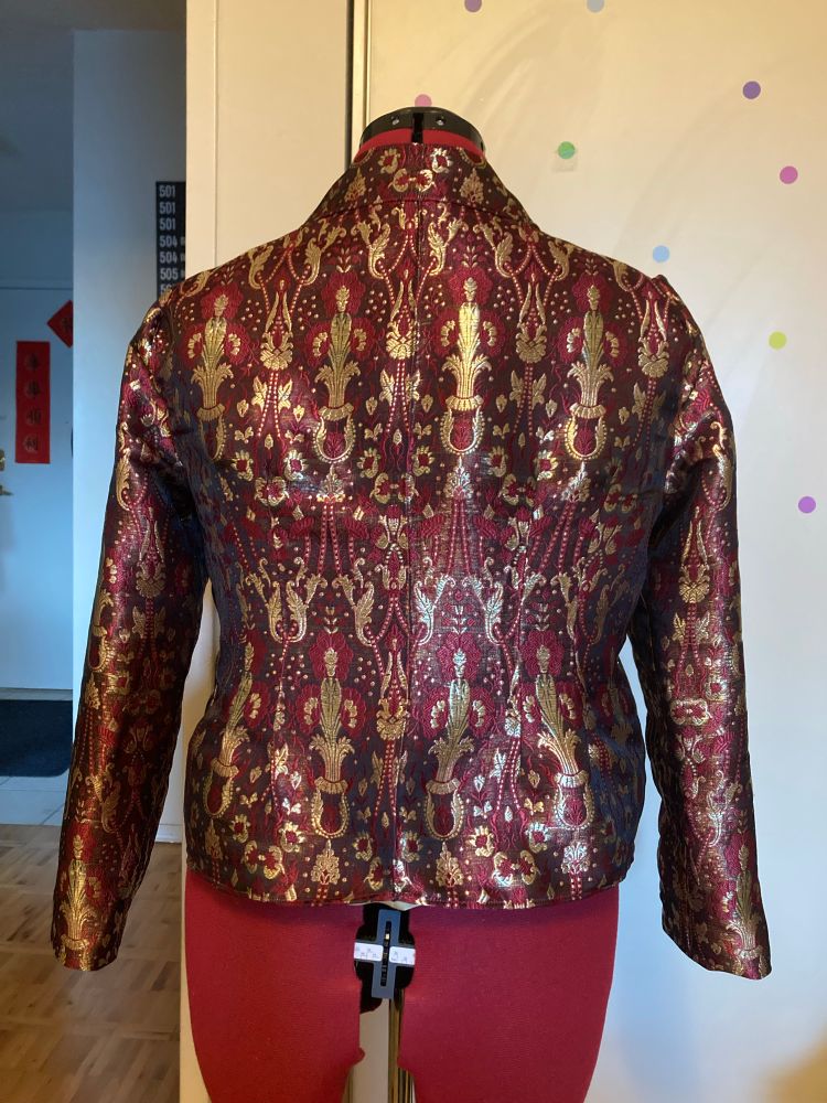 Back view of brocade jacket, showing darts that shape the waist