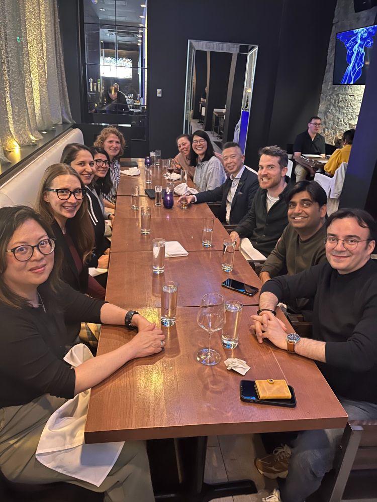 11 Code for Canada staff members sitting across a wooden table in a restaurant