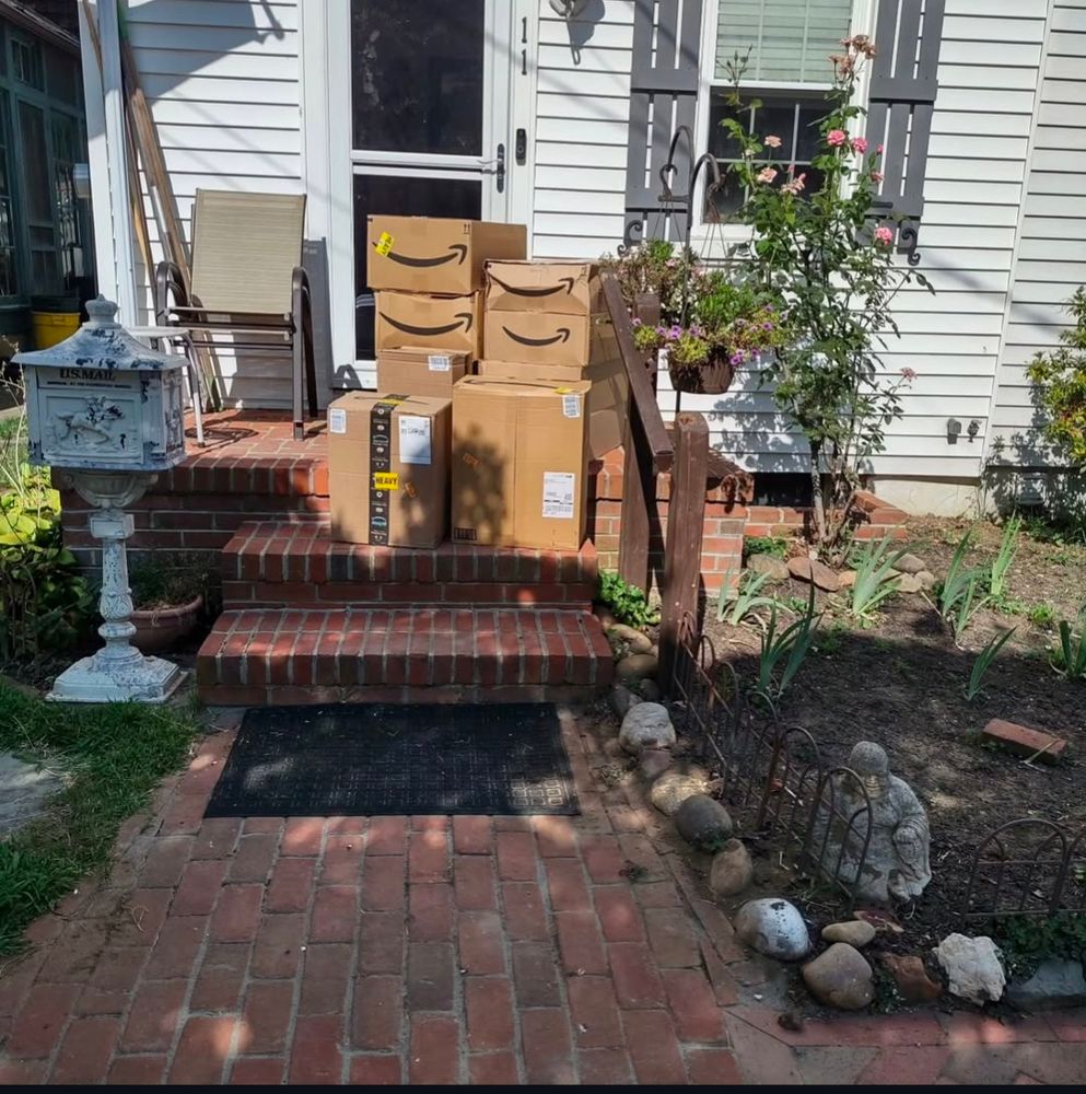 A multitude of Amazon boxes carrying donated supplies completely covering a front porch.
