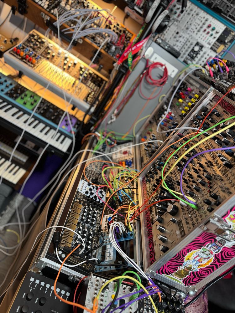 Modular synthesizer with colorful patch cables, Moog synthesiser and assorted studio equipment. 