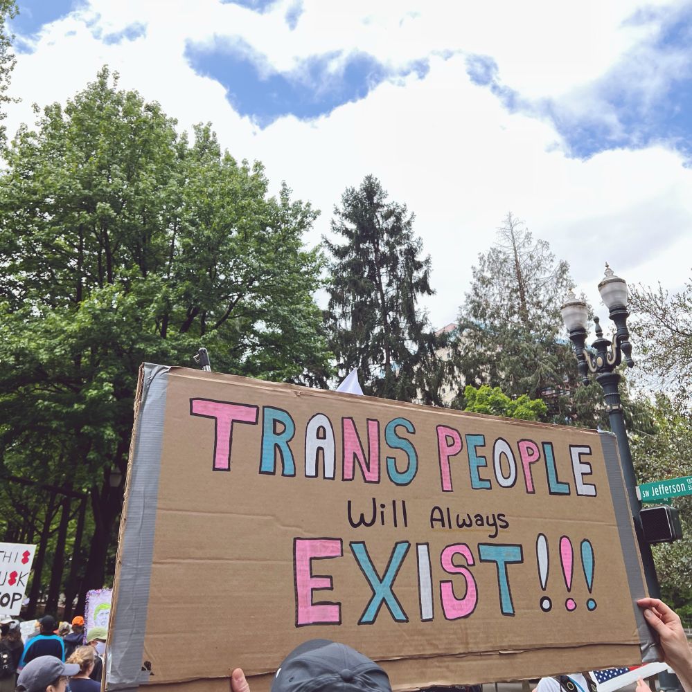 No Kings protest sign in Portland, Oregon reads: “TRANS PEOPLE WILL ALWAYS EXIST!!!”