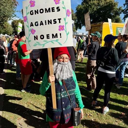Une manifestante de Portland déguisée en nain avec le slogan "Gnomes against Noem" (Kristi)
