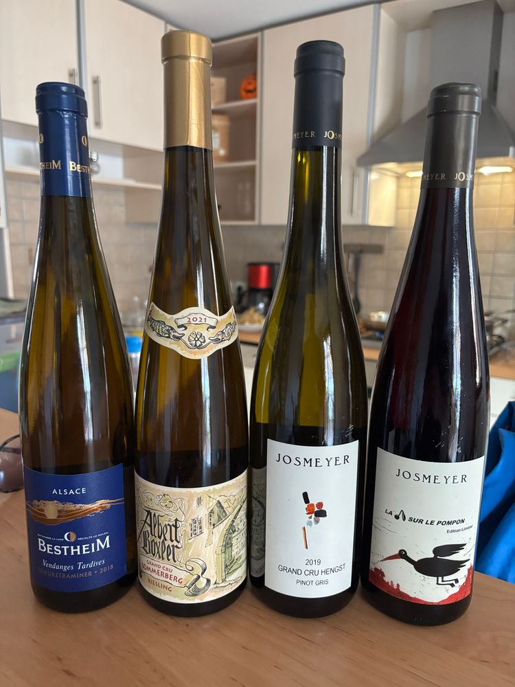 Four tall bottles of wine from Alsace sitting on a kitchen counter