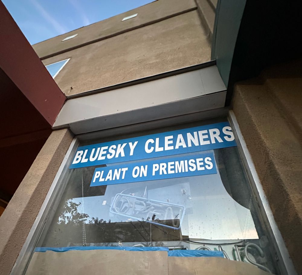 a sign on a window that says “bluesky cleaners - plant on premises”