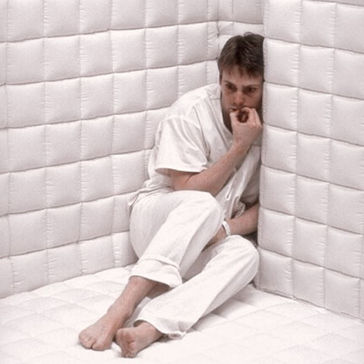 man in a white padded room