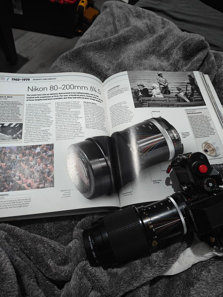 A photo of the book Photography: the definitive visual history by Tom Ang. Page 270, about the Nikon 80-200 f/4.5 zoom lens. 

Atop the book is MY 80-200 f/4.5 zoom lens, attached to a Nikon F3. I paid $60 for the lens. 