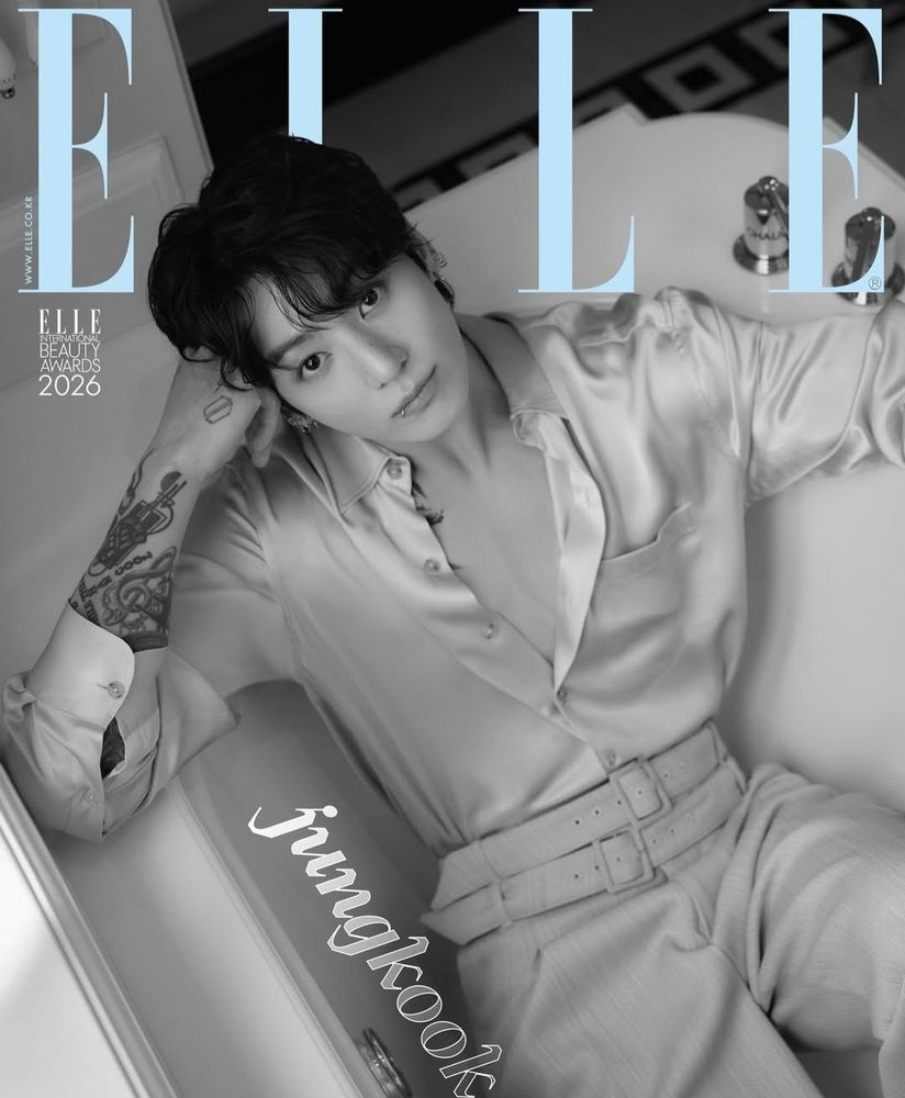 photo of Jungkook on the cover of Elle Korea. he's in a bath, photographed in black and white, wearing a silky shirt that is unbuttoned almost all the way