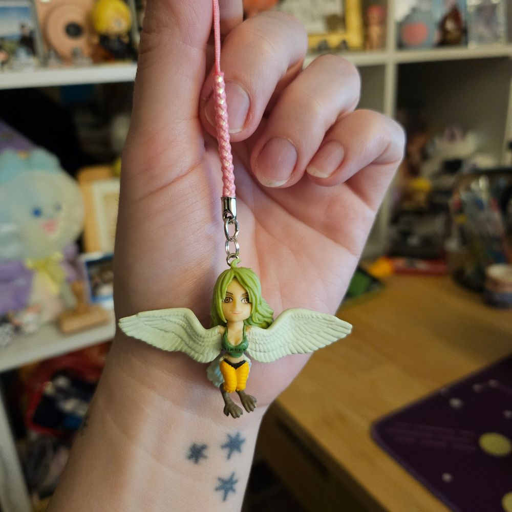 photo of a tiny monet from one piece figure on a pink cell phone strap