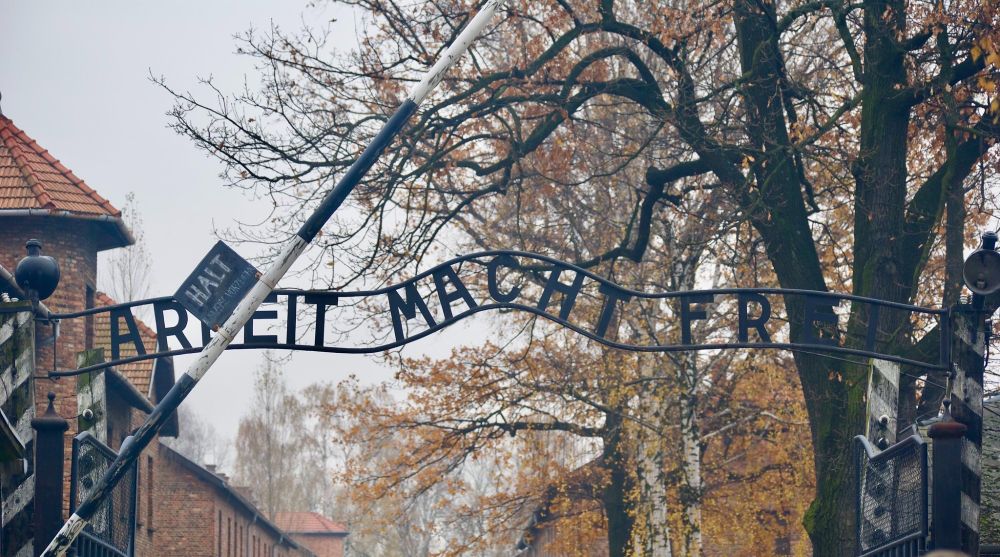 The entrance to Auschwitz Birkenau concentration camp, with a sign that reads "Arbeit Macht Frei"