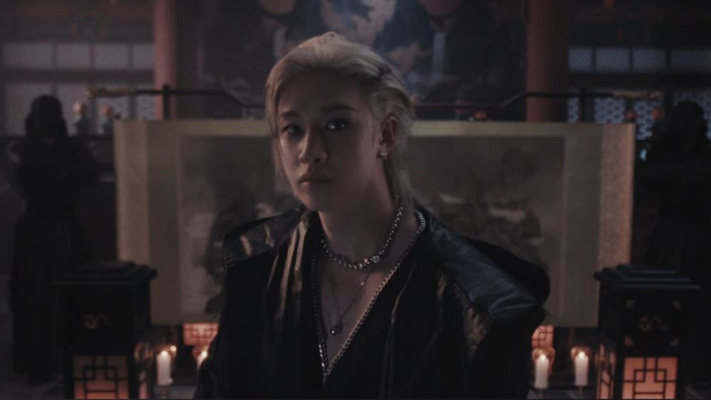 Chan looking to the camera with a serious face. 