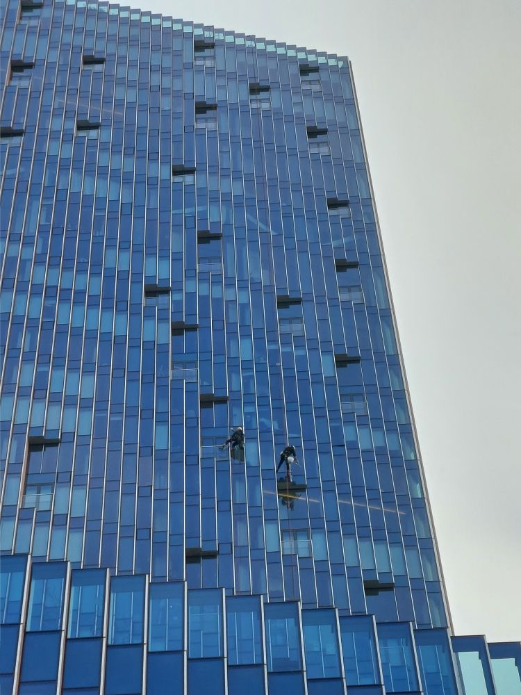 Two window cleaners on a glass skyscraper 
