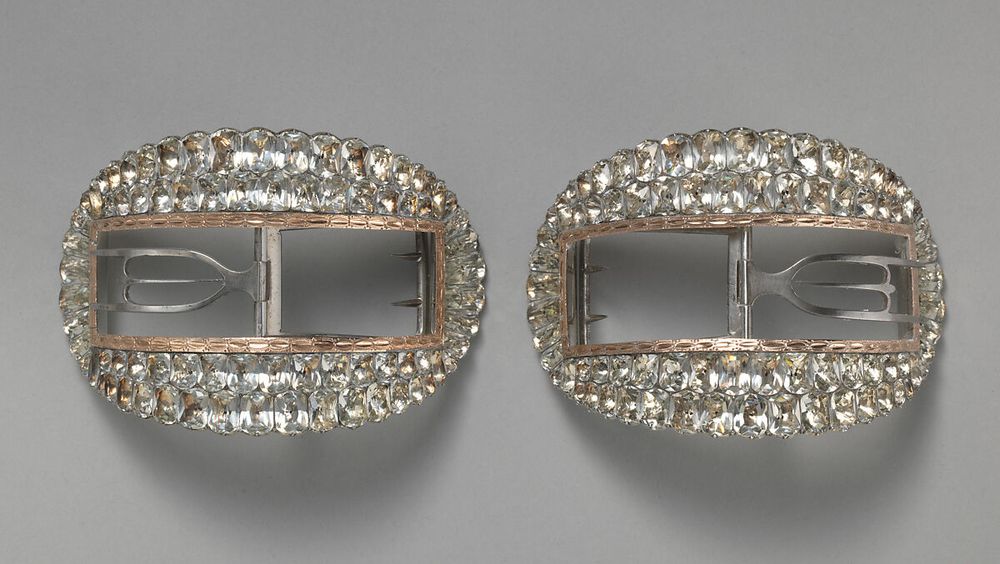 Two rectangular shoe buckles, surrounded by so many large paste diamonds that they take on an oval silhouette.