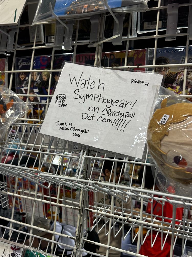 Sign that says watch symphogear on crunchyroll dot com please. Thank you, Miles Crunchyroll. “Dess”