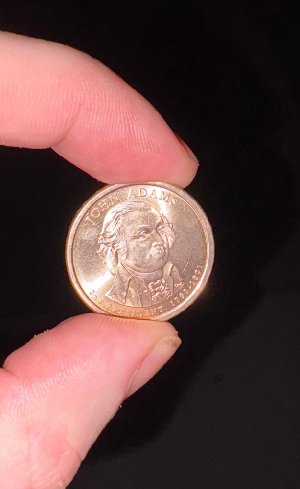 a dollar coin depicting second president of the united states john adams