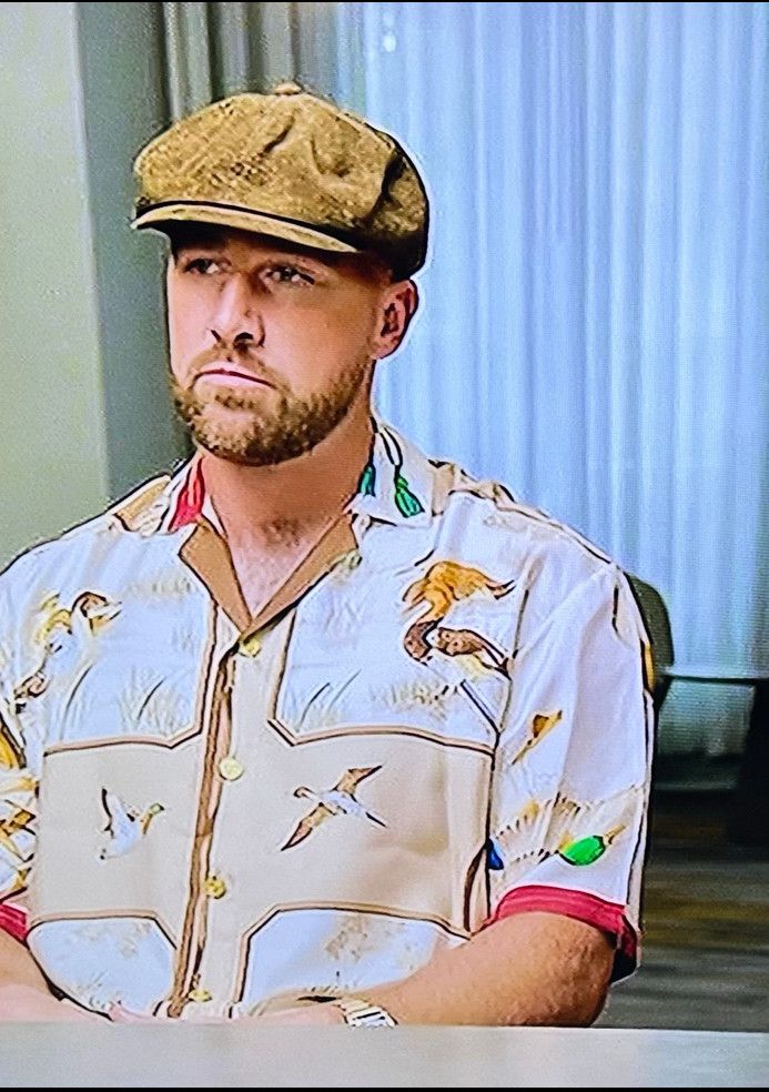 Travis Kelce wearing an old camper curtain look while being interrogated for crimes against fashion by brother Jason on ESPN.