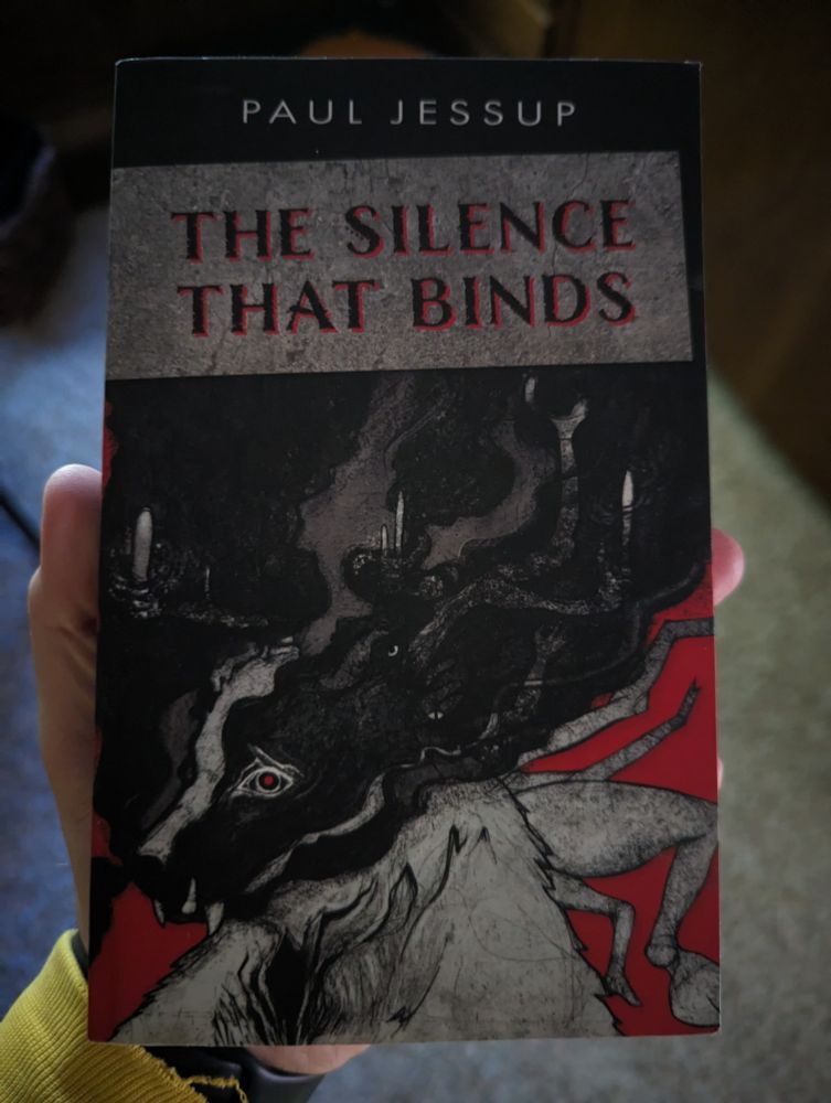 The cover of Paul Jessup's The Silence That Binds, featuring a black, white, and red image of a surreal dog face, darkness, candles, and limbs.