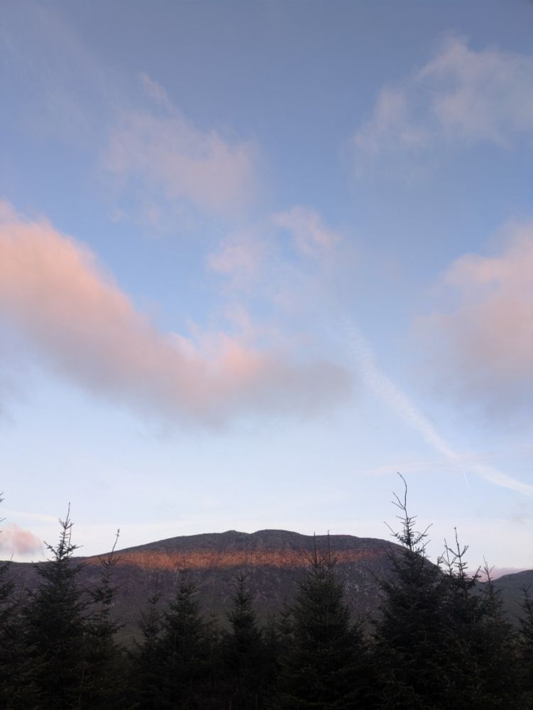 A strip of sunrise across a hill