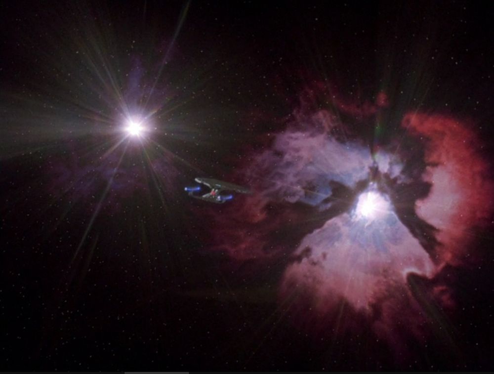 The final shot of Star Trek: The Next Generation, in season 7 episode 25 "All Good Things." The starship Enterprise flies away from the camera into a binary star system surrounded by a purple nebula.