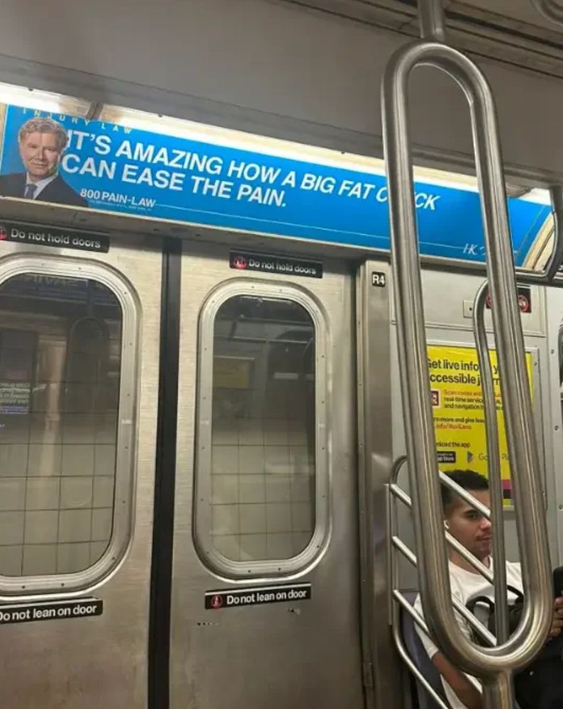 A subway ad sign for an attorney saying it's amazing how a big fat check can ease the pain but there was a pole in front of the word check and it looks like a different word