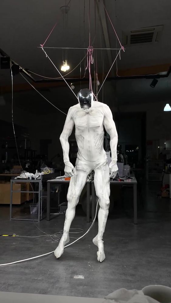 Protoclone synthetic robot hanging from wires
